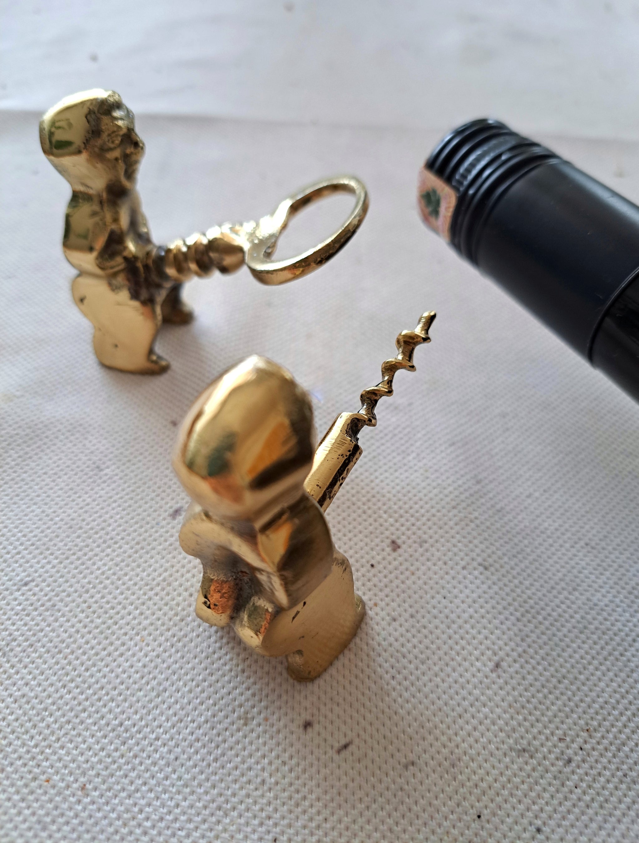 Brass corkscrew and bottle opener shaped like a fertility god figure