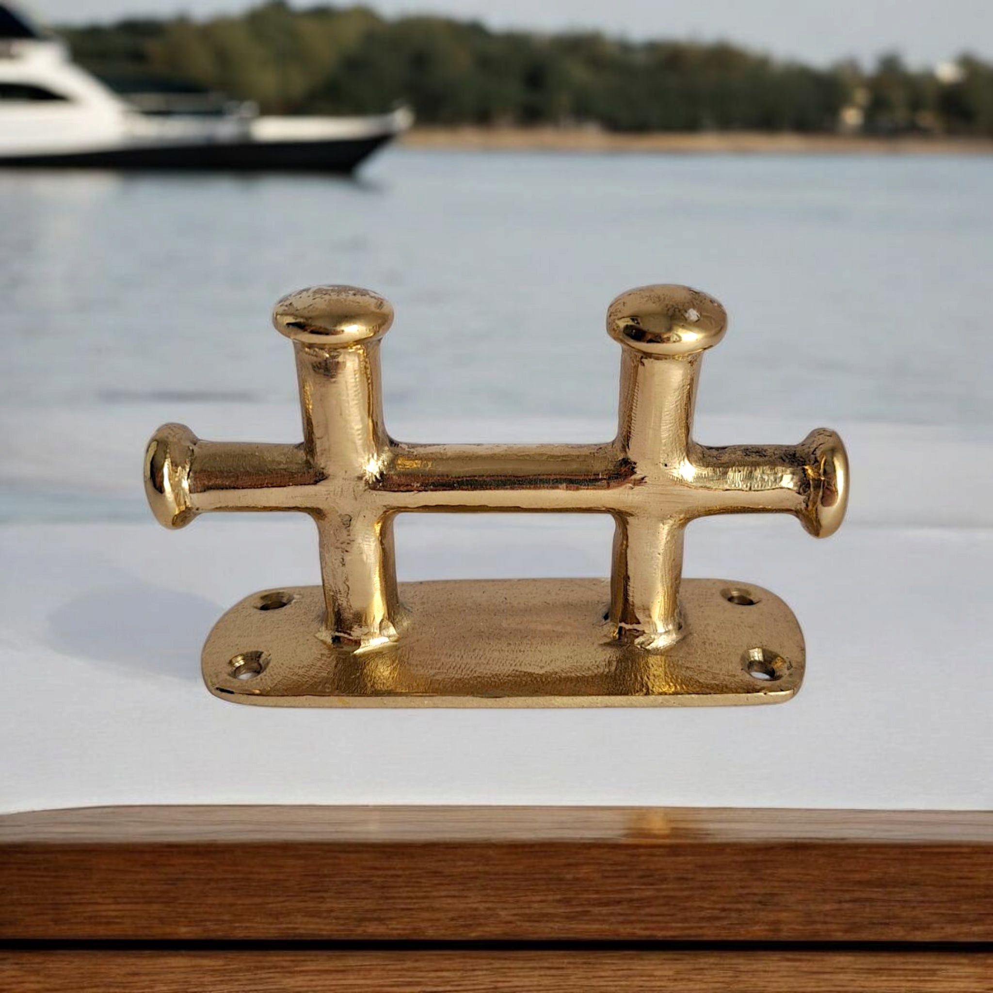 Small 12cm brass boat cleat on seaside background