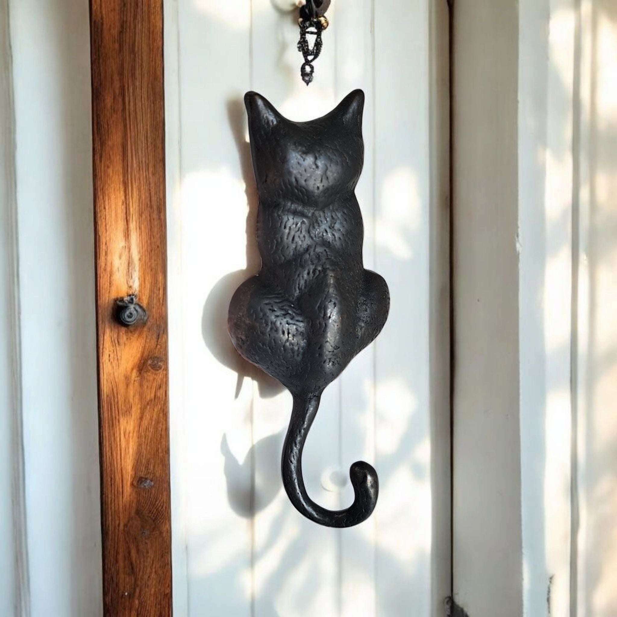 Antique brass cat knocker with detailed tail design