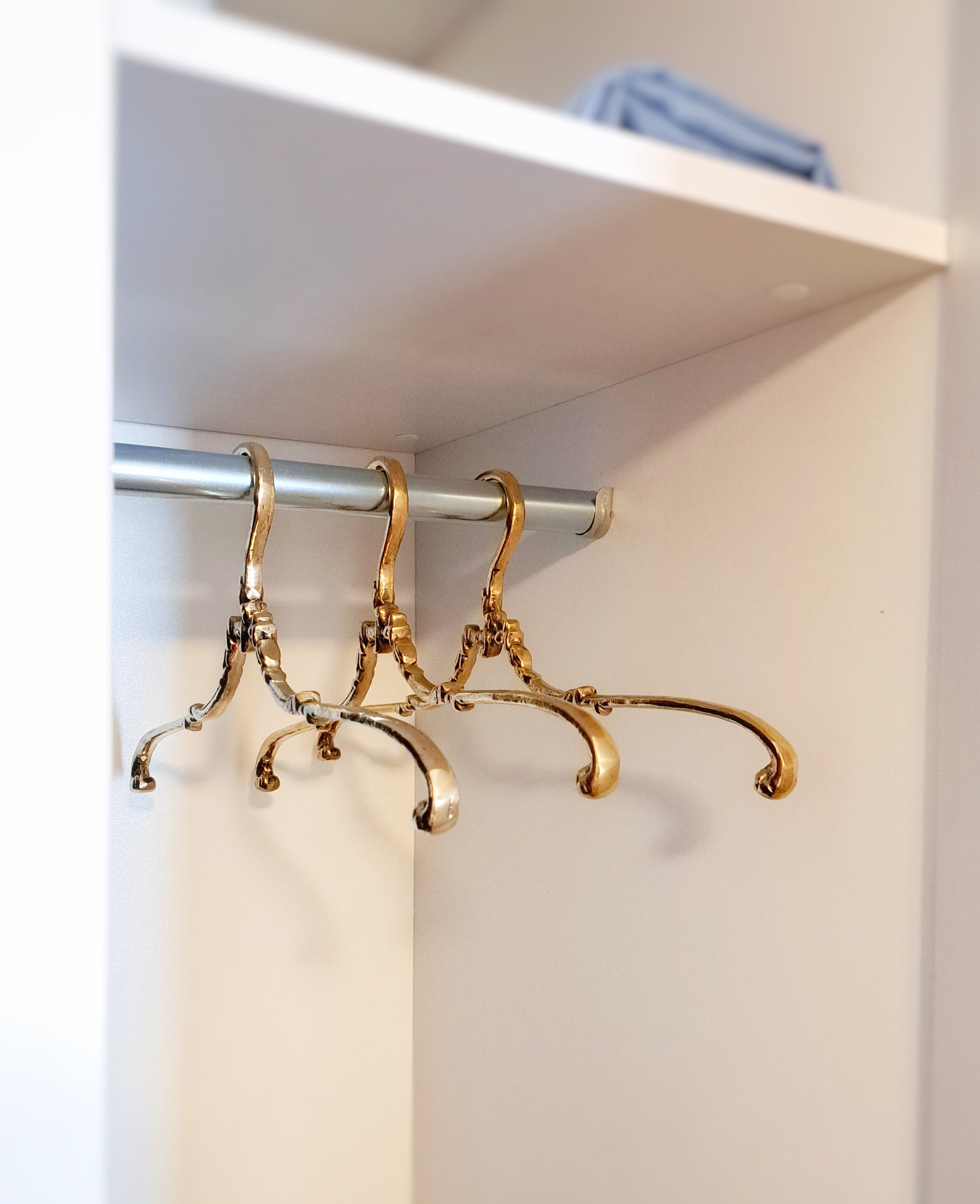 Gold hooks on a white shelf
