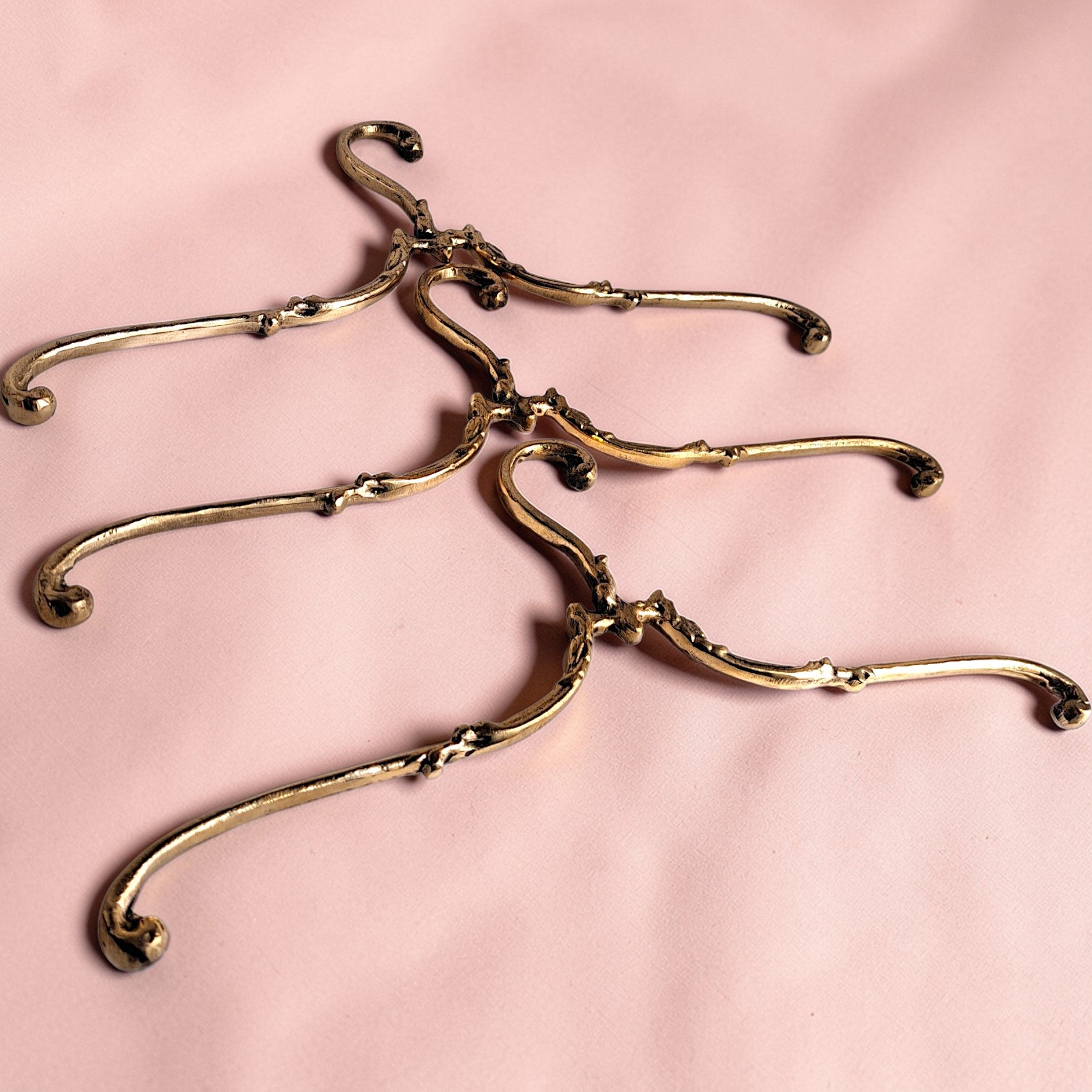 Set of gold hangers on a pink background