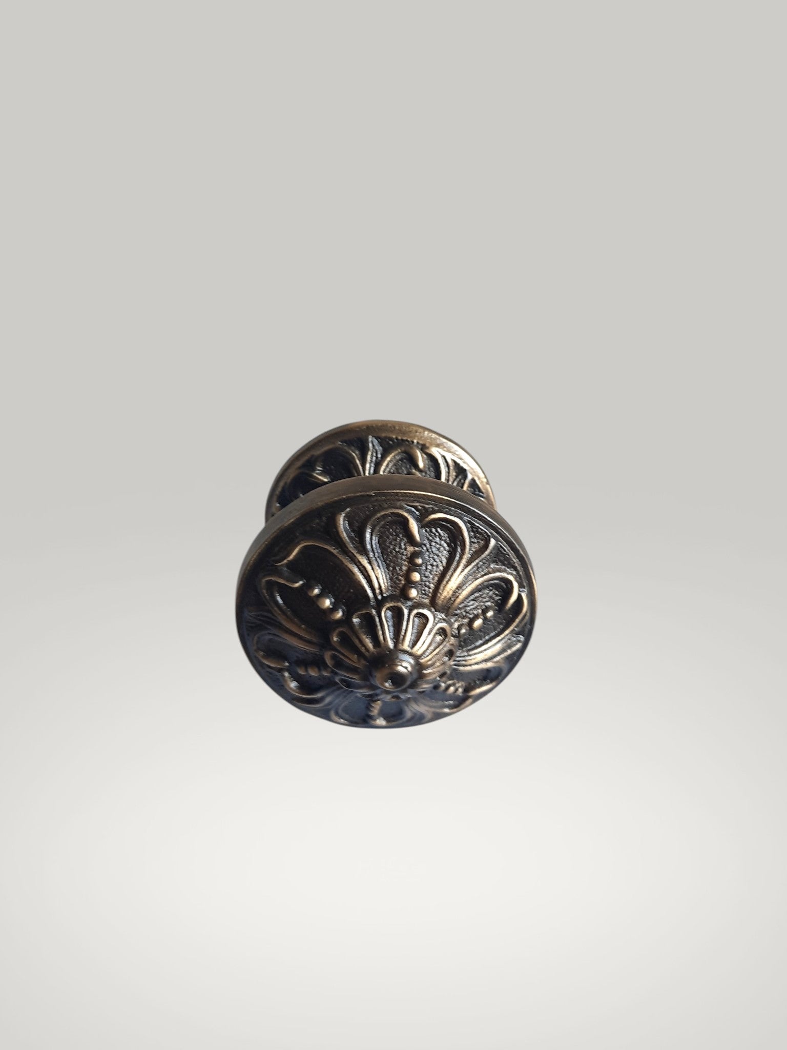 Decorative metal door knob on a light gray background