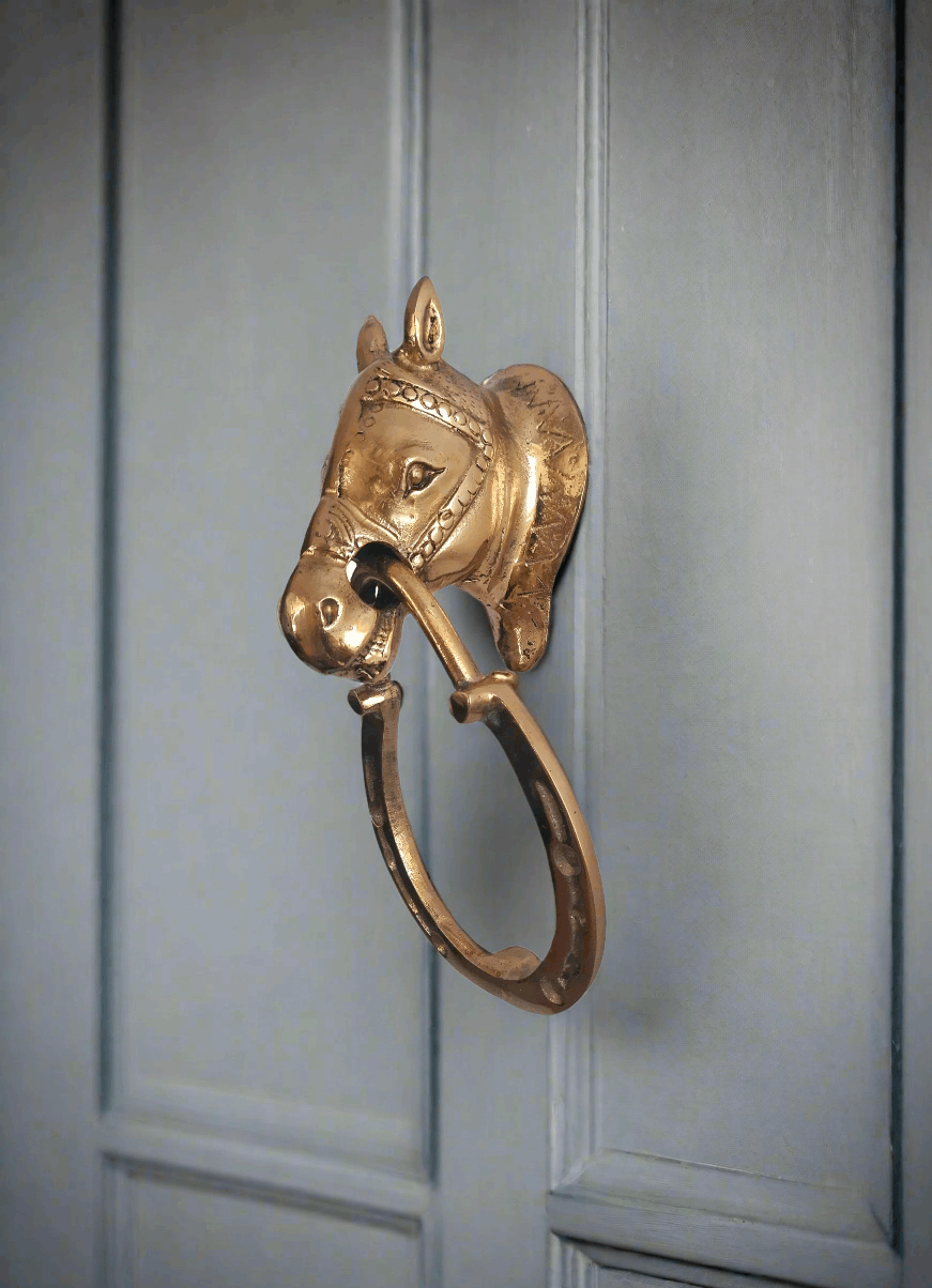Side view of horse-shaped vintage door knocker in brass