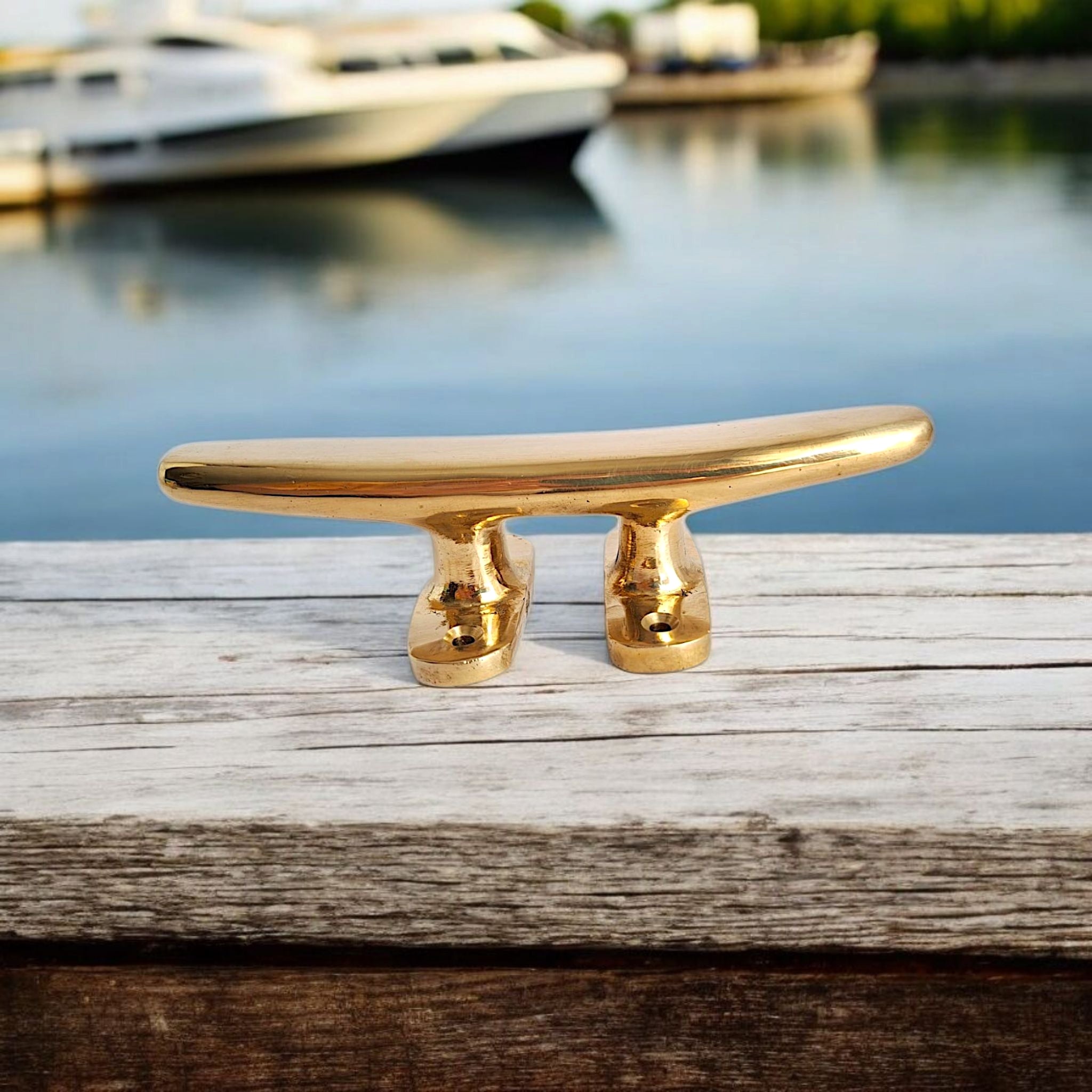 Polished 18cm brass cleat on wooden dock surface