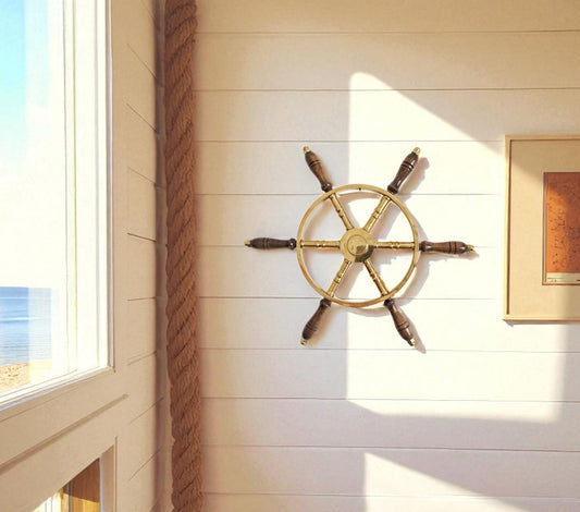 Nautical wheel on a wall with a window showing a beach view