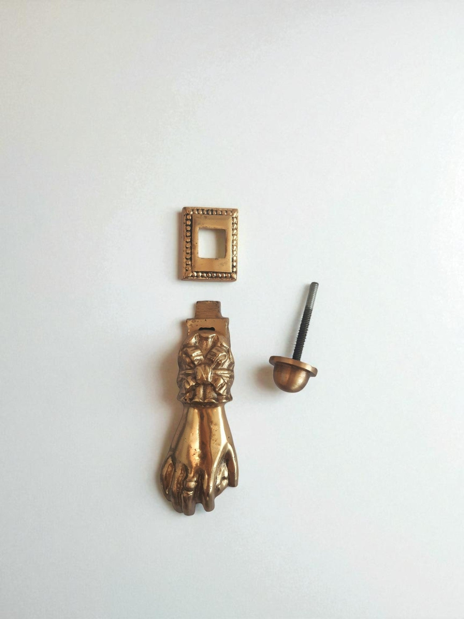 Vintage-style brass door handle and lock components on a white background