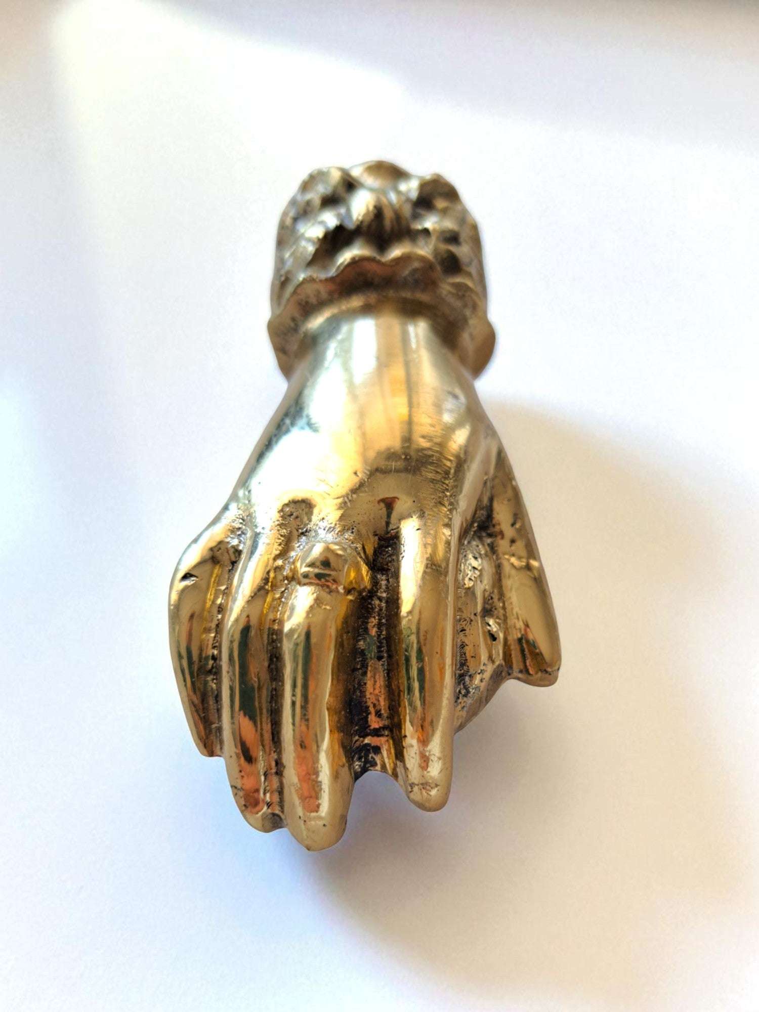 Gold hand-shaped object on a white background