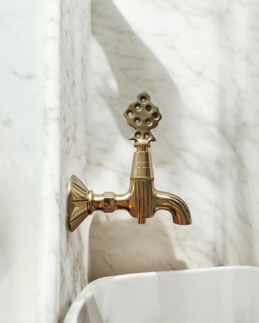 Turkish Ottoman-inspired brass faucet installed on a marble wall