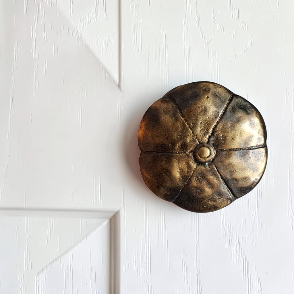 Antique brass floral fixed door knob mounted on a white door