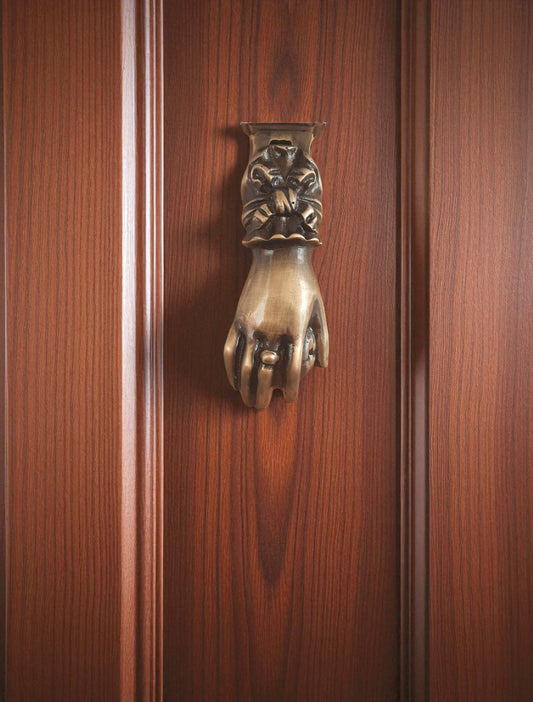 Decorative door knocker shaped like a hand on a wooden door