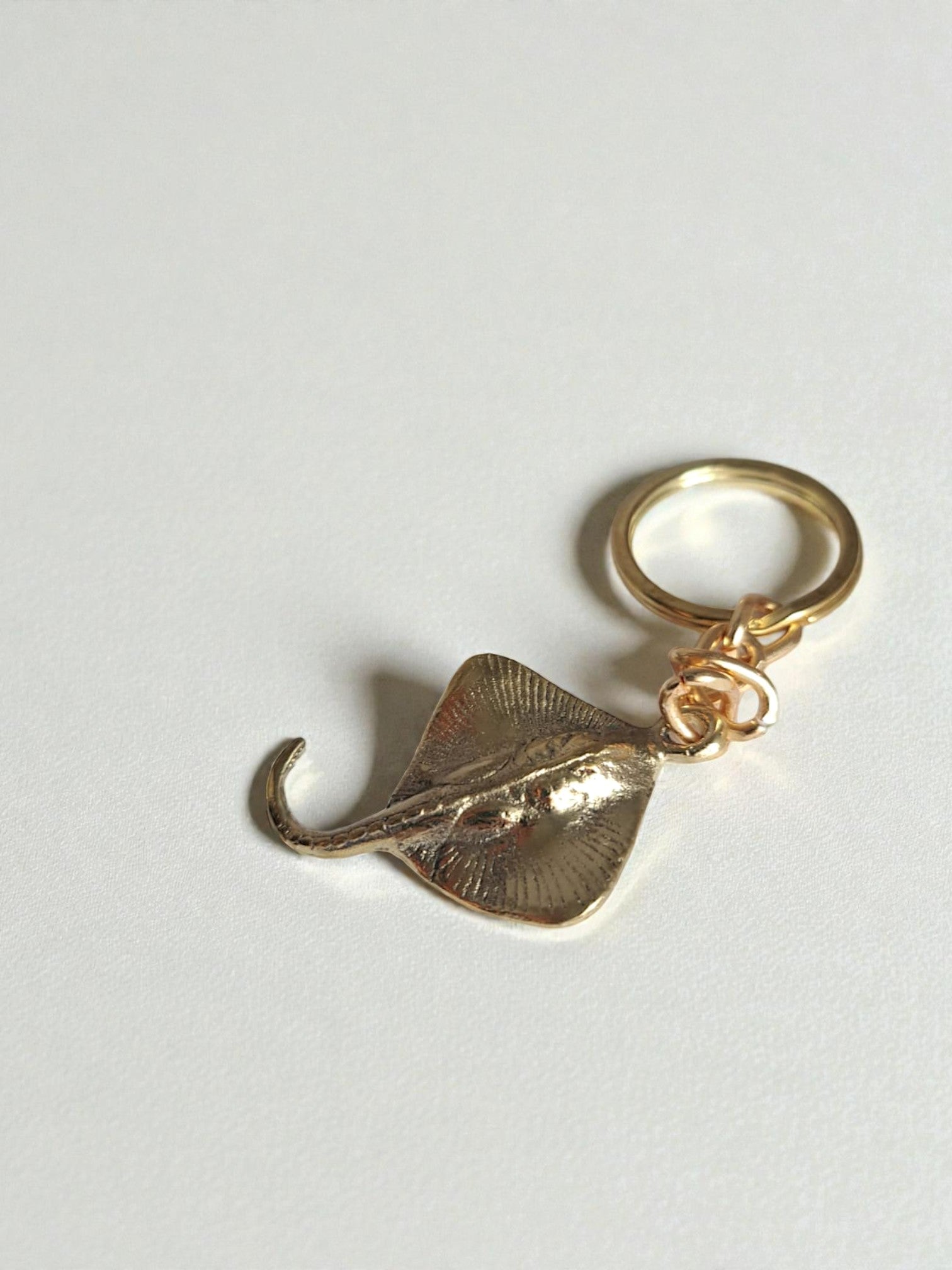 Gold stingray charm on a white background