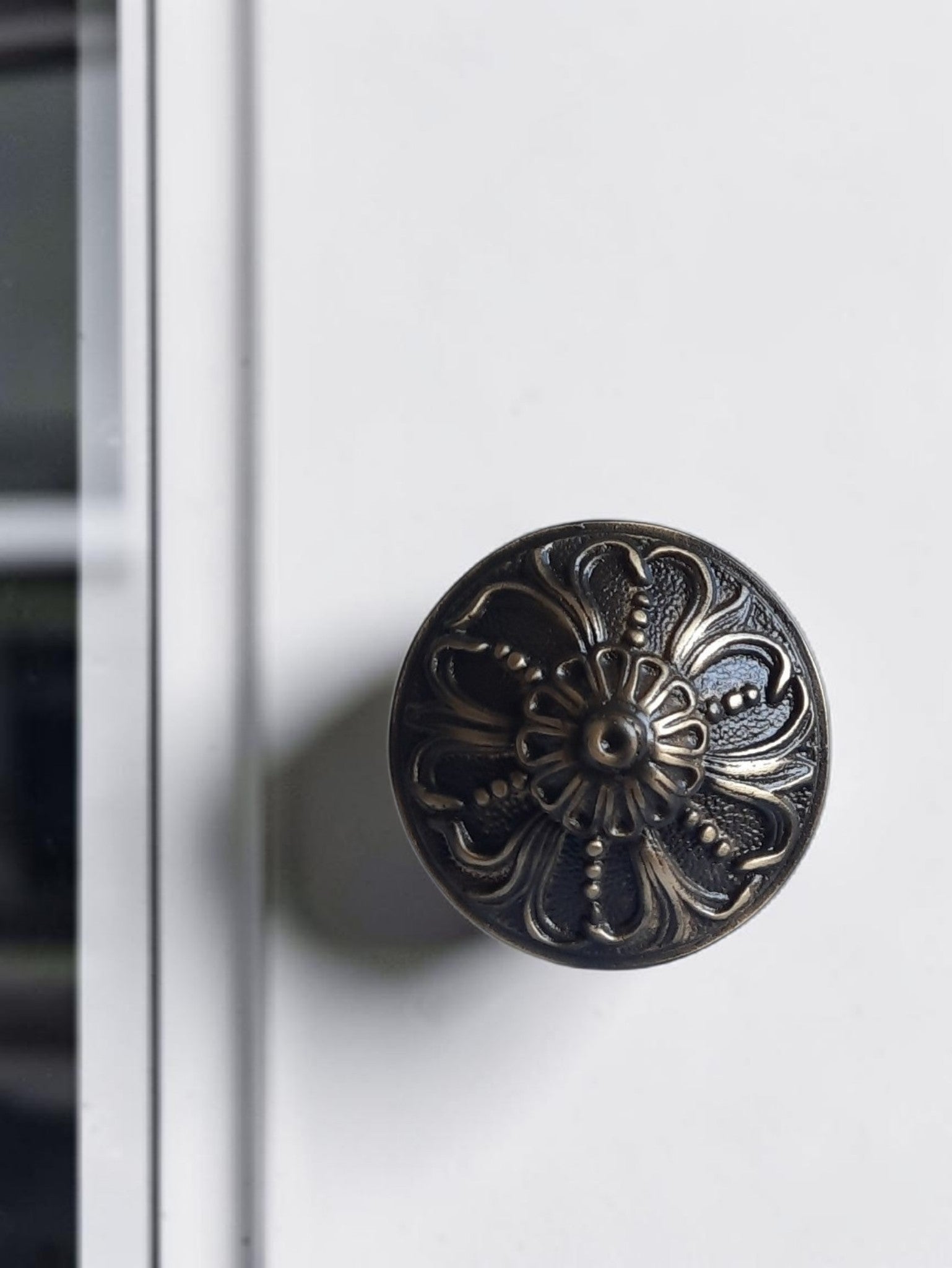 Decorative black door handle on a white door