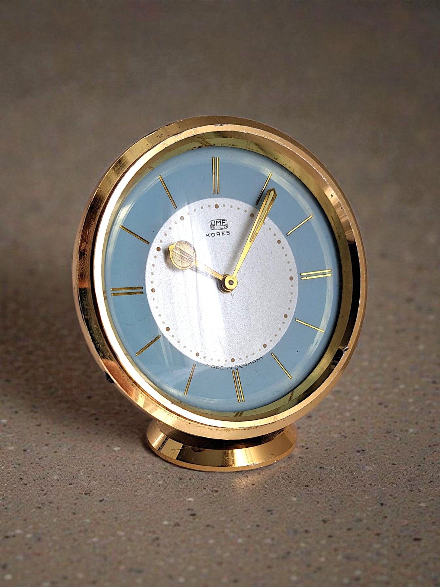 vintage wind-up desk clock with blue dial and brass body