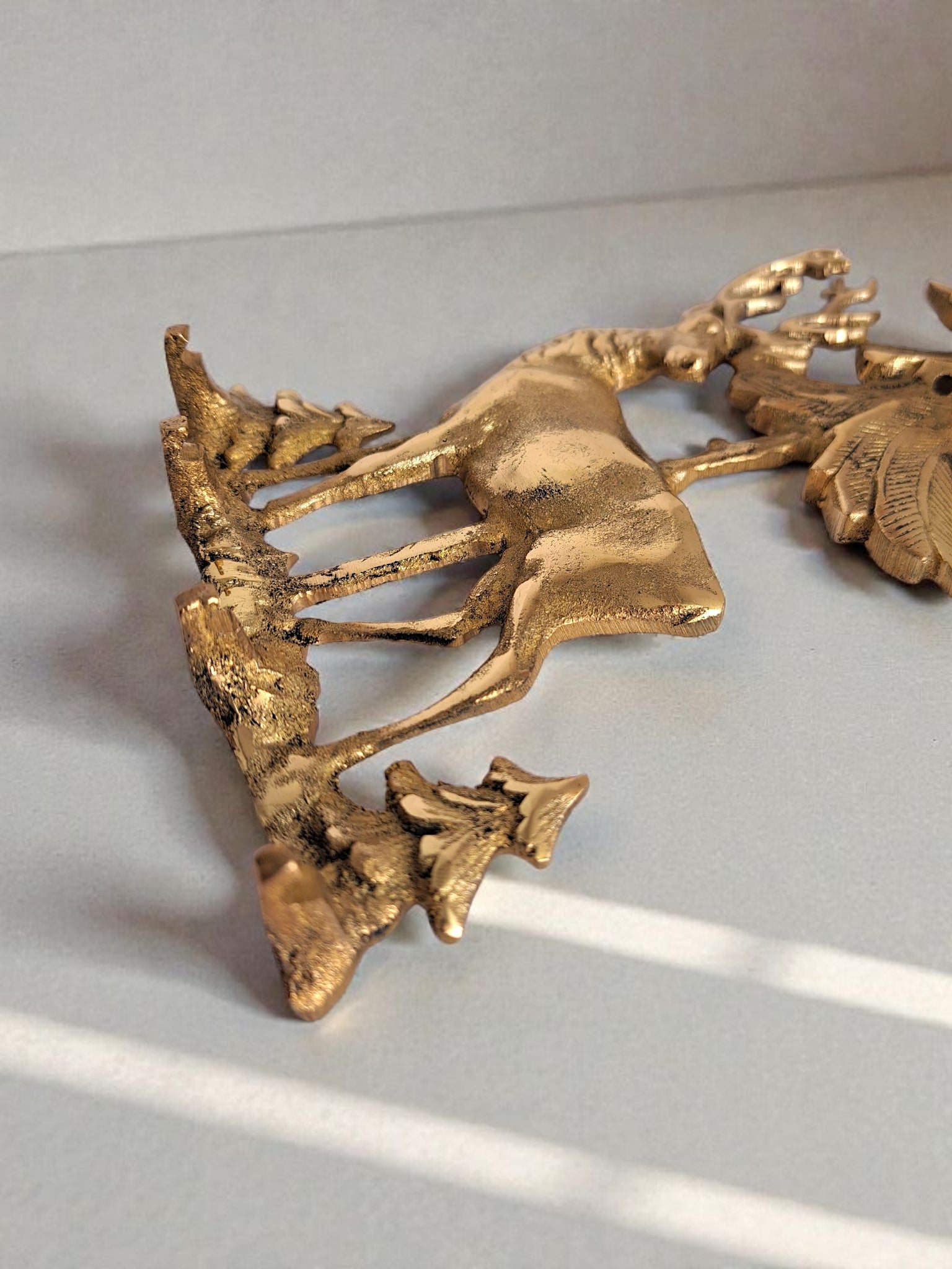 Gold decorative wall piece on a light gray background