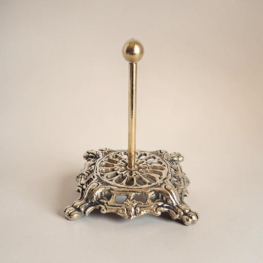 Decorative metal stand with a spherical top on a beige background